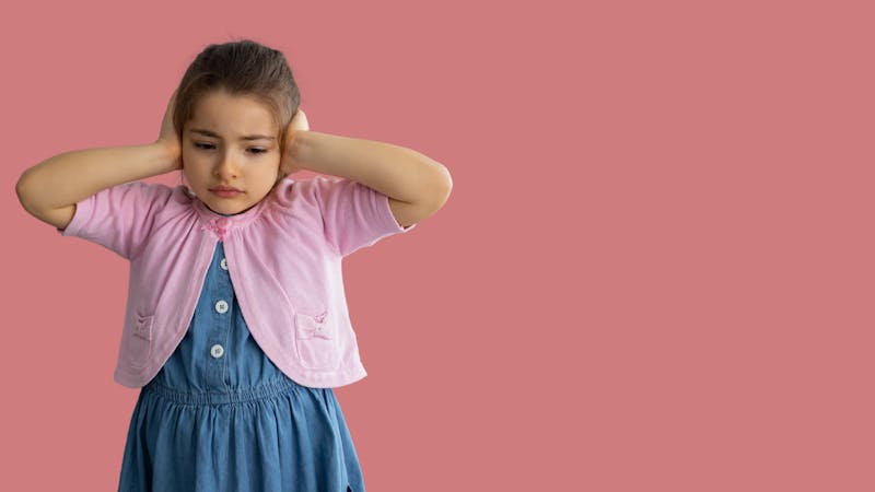 girl covering ears from shouting and stressful situation