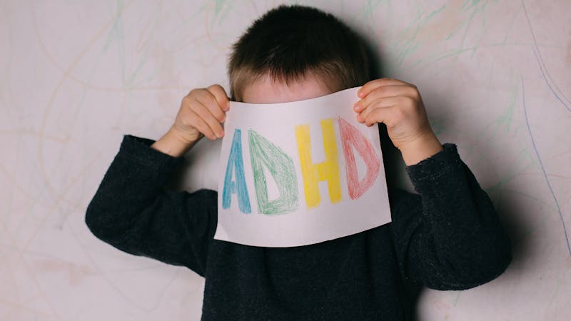 child holding up ADHD sign