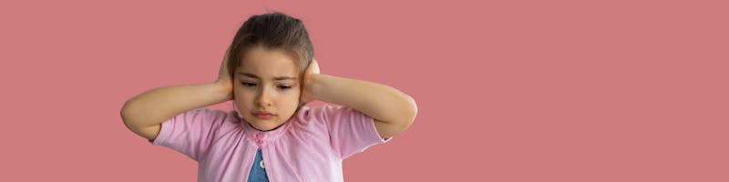 child covering ears from traumatic stress